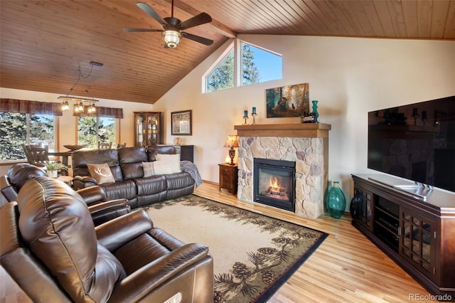 living room with wood ceiling, light hardwood / wood-style flooring, ceiling fan, a fireplace, and beamed ceiling