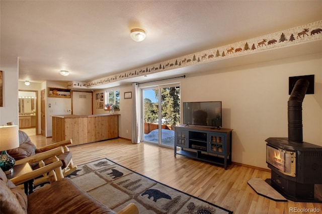 living room with a wood stove and light wood-type flooring