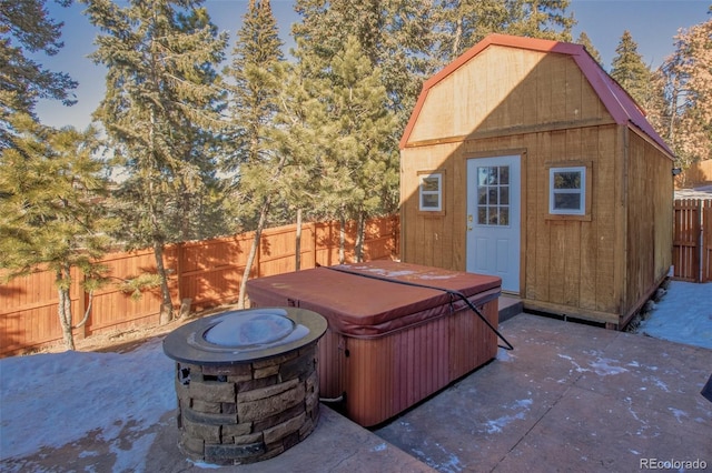 view of patio featuring a shed and a hot tub