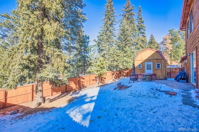 view of yard with a storage shed and an outdoor fire pit