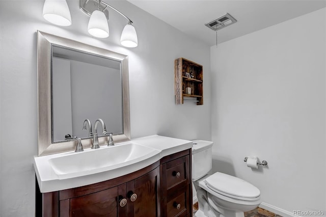 half bath with toilet, visible vents, and vanity