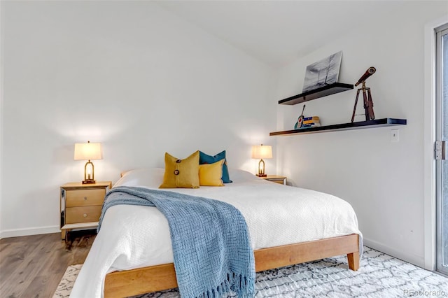 bedroom with wood finished floors and baseboards