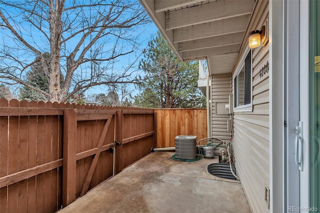 view of patio featuring a gate, fence, and central AC