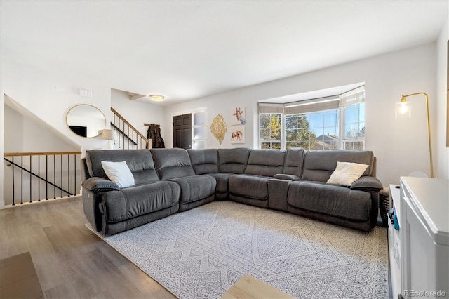 living area with stairs, visible vents, and wood finished floors