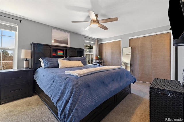 bedroom featuring two closets, a ceiling fan, and light colored carpet