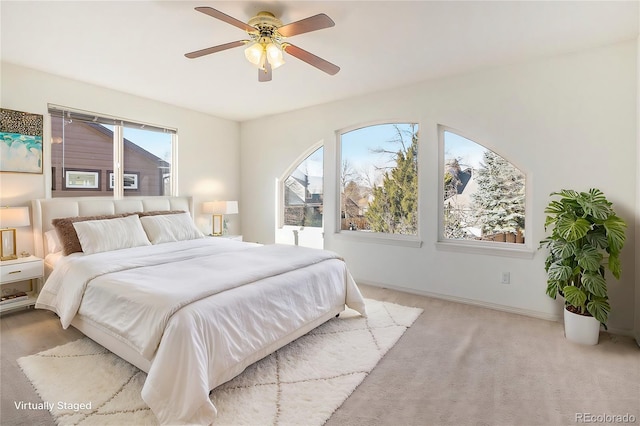 bedroom featuring light carpet, multiple windows, and ceiling fan