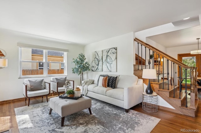 living room with wood finished floors, stairs, and baseboards