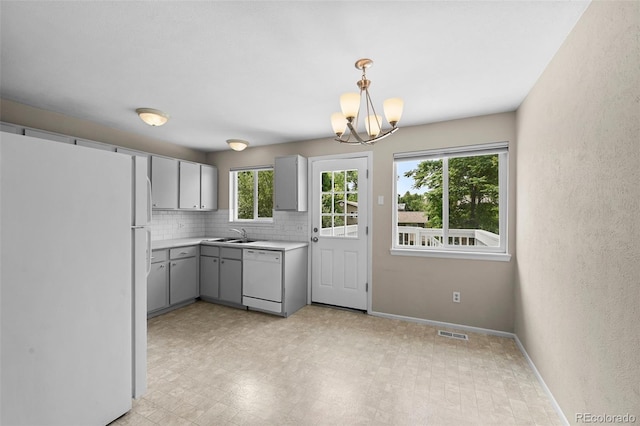 9196 W Maplewood Ave, Littleton, CO 80123 - kitchen with white appliances, gray cabinetry, a chandelier, light countertops, and tasteful backsplash