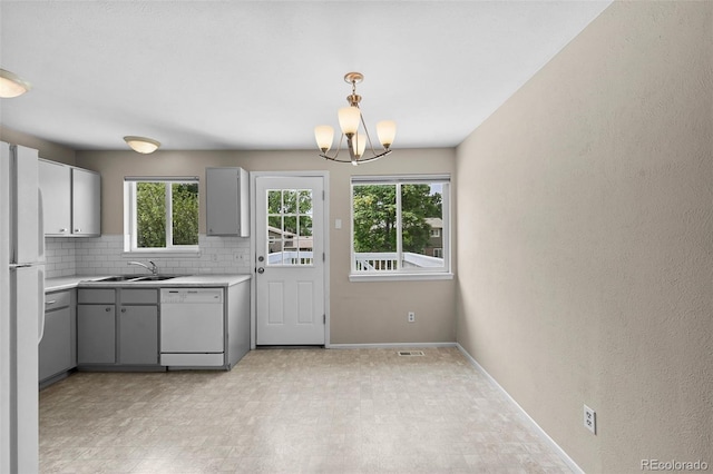 9196 W Maplewood Ave, Littleton, CO 80123 - kitchen with white appliances, light countertops, plenty of natural light, and gray cabinetry