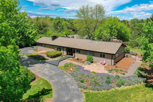 4701 Homestead St, Bow Mar, CO 80123 - ranch-style house featuring a chimney, a shingled roof, and a wooded view