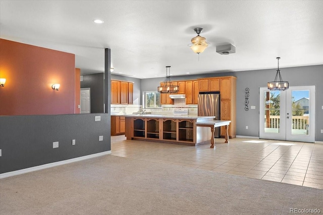 kitchen with light carpet, decorative light fixtures, plenty of natural light, and a center island