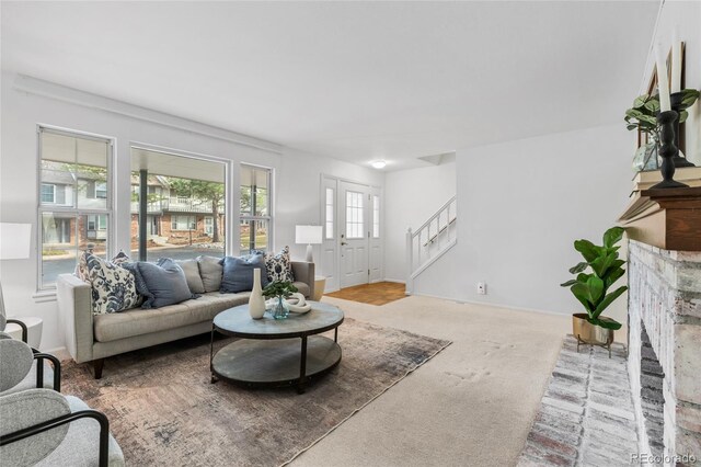 carpeted living area featuring stairs