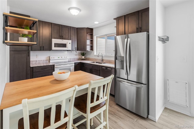 kitchen featuring open shelves, a sink, stainless steel appliances, light countertops, and dark brown cabinets