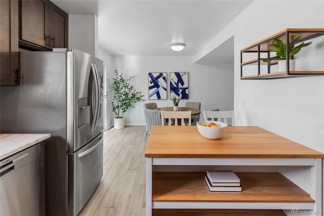 kitchen featuring dark brown cabinetry, stainless steel appliances, light wood-type flooring, and light countertops