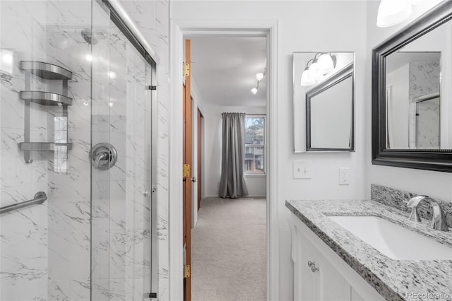 full bathroom with vanity and a marble finish shower