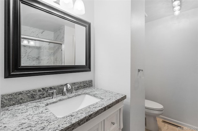 full bathroom with a marble finish shower, visible vents, baseboards, toilet, and vanity