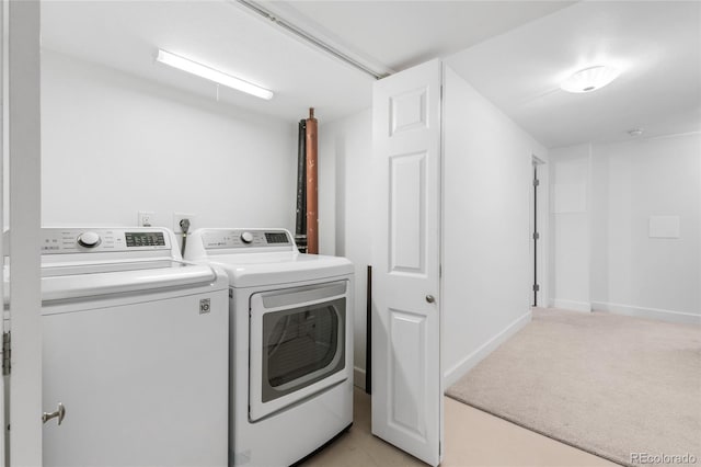 laundry room with laundry area, light colored carpet, baseboards, and washer and clothes dryer