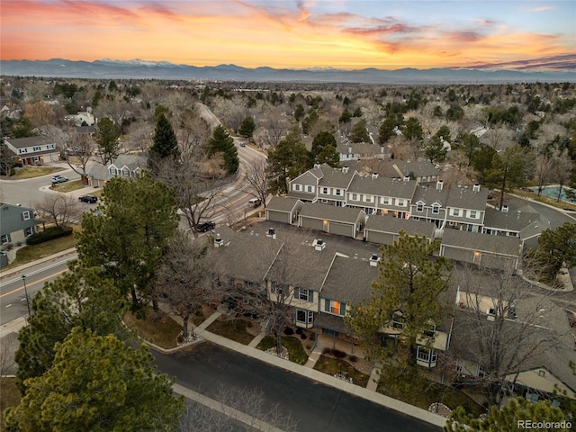 aerial view at dusk featuring a mountain view and a residential view