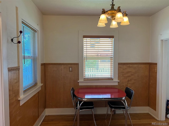 40 Bronk St, Monte Vista, CO 81144 - dining space with wood finished floors, wainscoting, a chandelier, and wood walls