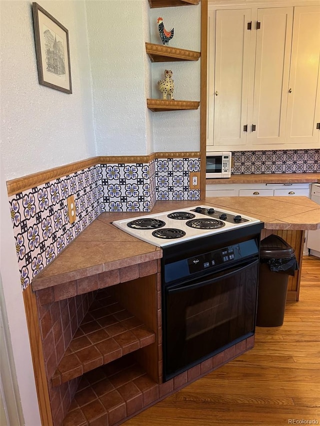 40 Bronk St, Monte Vista, CO 81144 - kitchen with light wood-style floors, white cabinets, backsplash, open shelves, and white appliances