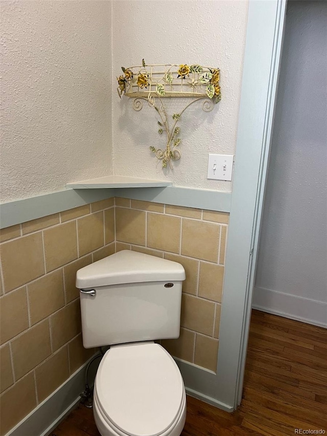 40 Bronk St, Monte Vista, CO 81144 - bathroom featuring wood finished floors, tile walls, and wainscoting