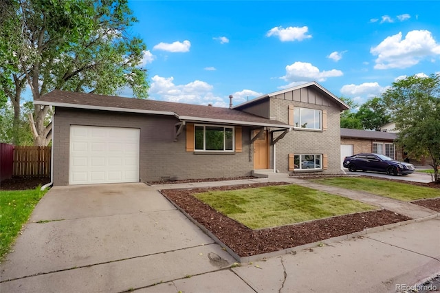 14544 March Dr, Denver, CO 80239 - split level home featuring brick siding, a garage, driveway, and board and batten siding