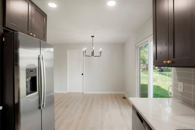 14544 March Dr, Denver, CO 80239 - kitchen with stainless steel fridge, light wood-style floors, dark brown cabinets, light countertops, and a chandelier