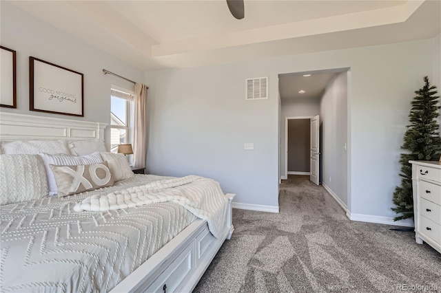 bedroom with a tray ceiling and light colored carpet