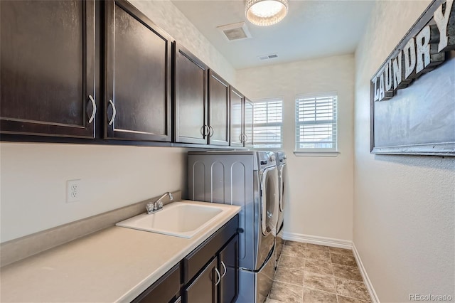 washroom with sink, cabinets, and washing machine and clothes dryer