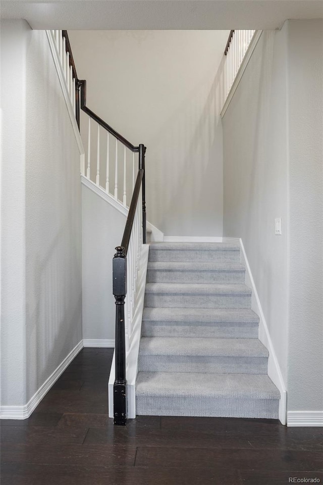 stairway featuring baseboards and wood finished floors