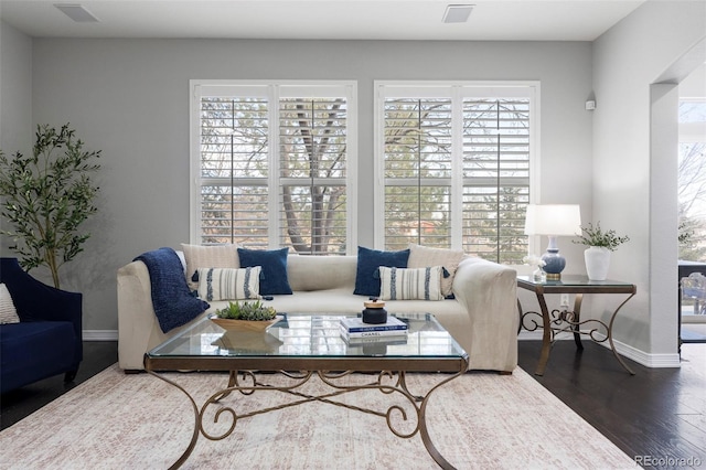 living room featuring visible vents, baseboards, and wood finished floors