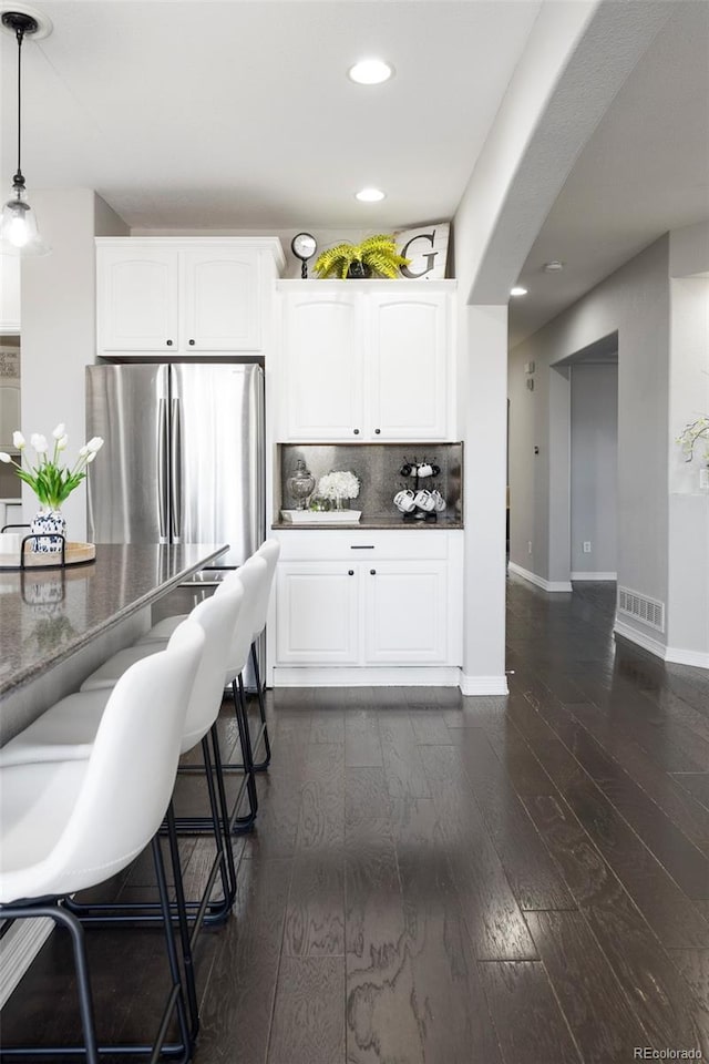 kitchen featuring visible vents, tasteful backsplash, dark wood-style floors, and white cabinets