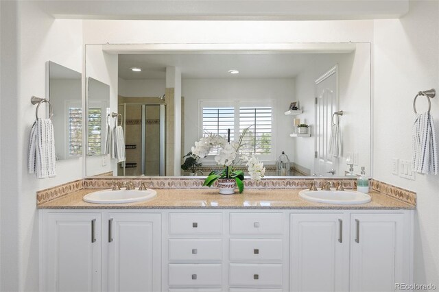 bathroom with a sink, double vanity, and a shower stall