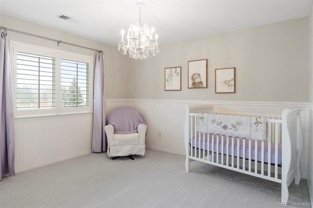 bedroom featuring a wainscoted wall, an inviting chandelier, carpet, and visible vents