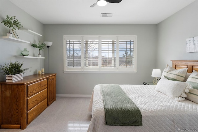 bedroom featuring visible vents, light colored carpet, baseboards, and ceiling fan