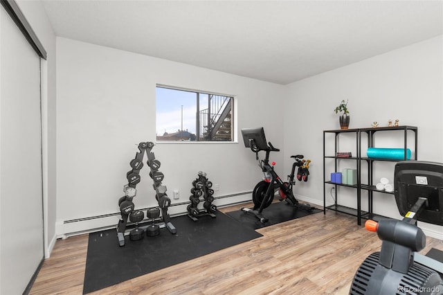 exercise room featuring baseboards and wood finished floors