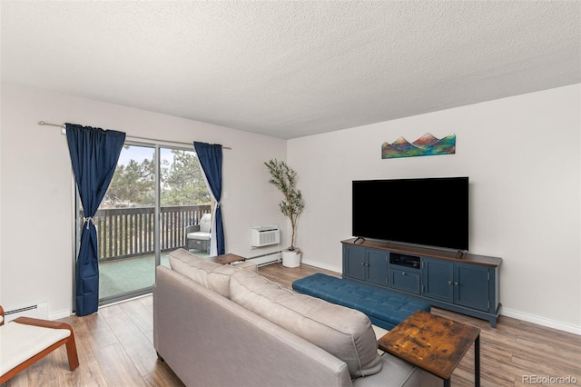 living room with baseboards, light wood-style floors, a baseboard radiator, and a textured ceiling
