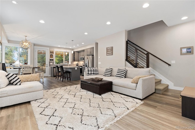 living room featuring an inviting chandelier and light hardwood / wood-style flooring