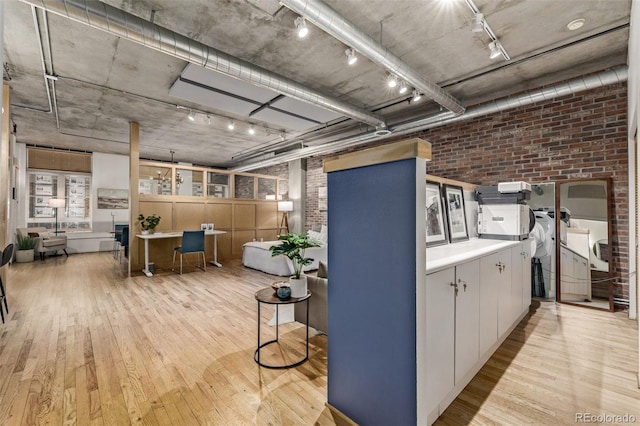 interior space featuring light hardwood / wood-style flooring and brick wall