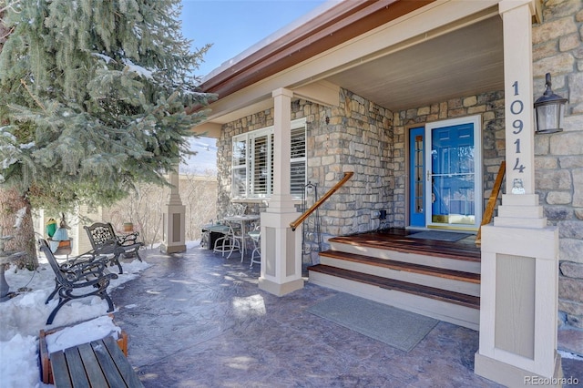 doorway to property featuring stone siding and a patio