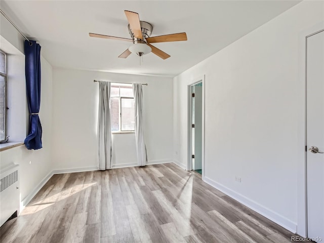 500 E 11th Ave Unit 203, Denver, CO 80203 - unfurnished bedroom featuring radiator heating unit, wood finished floors, and ceiling fan