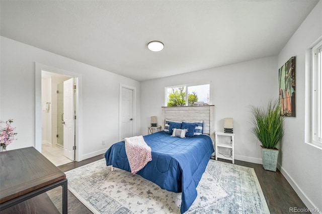 4640 W Ellsworth Ave, Denver, CO 80219 - bedroom featuring dark wood-style floors, baseboards, and connected bathroom