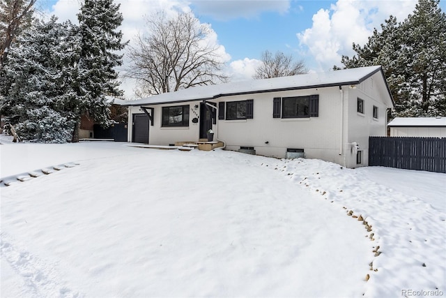 single story home with an attached garage and fence