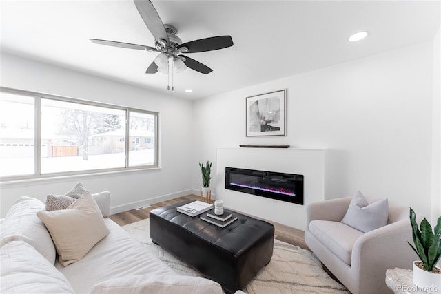 living room with ceiling fan and light hardwood / wood-style flooring