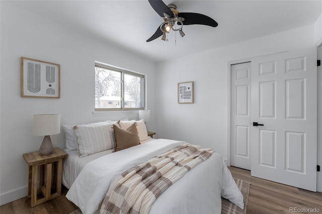 bedroom with ceiling fan, a closet, and hardwood / wood-style flooring