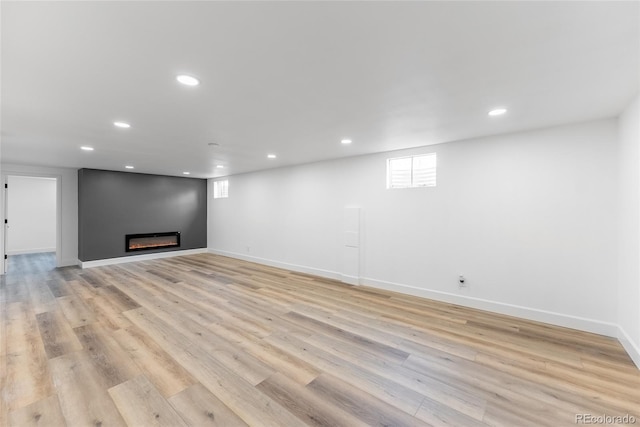 basement with light hardwood / wood-style flooring