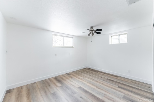 spare room featuring light wood-type flooring and plenty of natural light