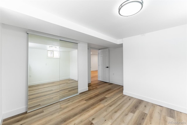 unfurnished bedroom with light hardwood / wood-style flooring and a closet