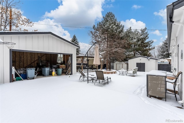 yard covered in snow featuring a shed