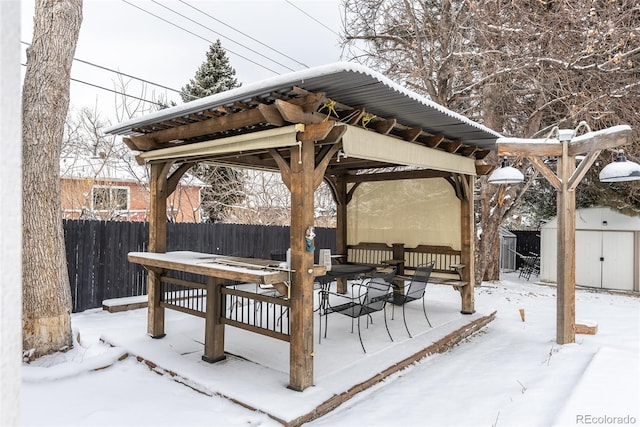 snow covered patio featuring outdoor lounge area and a shed